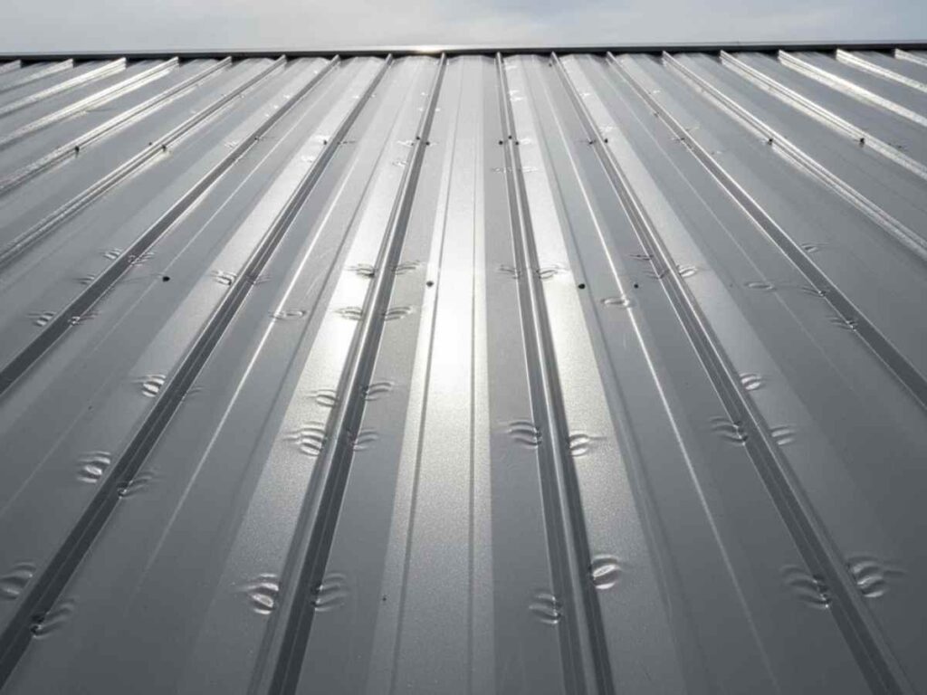 metal roof panel showing small hail dents across surface